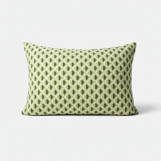 Green and white patterned pillow on a white background